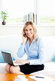smiling business woman on phone working at home with laptop