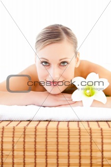 Close-up of a radiant woman lying on a massage table with a flow
