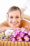 Pretty woman with flowers enjoying a head massage