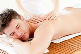 Charismatic relaxed man enjoying a back massage in a spa center