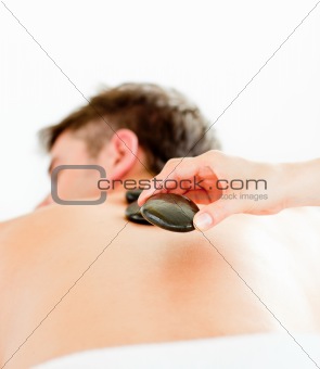 Close-up of a positive young man having a back massage with hot 