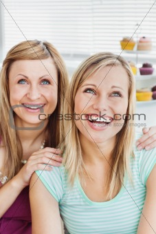 Portrait of laughing friends sitting in the kitchen 