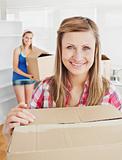 Delighted woman holding boxes after moving 