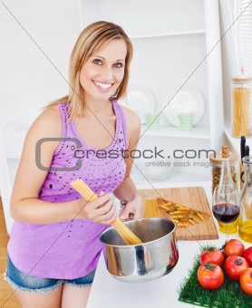 Glowing woman cooking spaghetti at home 