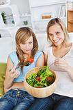 Hungry women eating a salad in the living-room