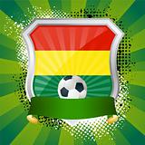 Shiny metal shield on bright background with flag of Bolivia