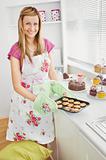 Positive young woman baking cookies in the kitchen