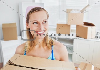 Positive woman carrying boxes at home