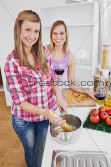 Radiant women cooking spaghetti together in the kitchen