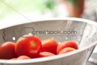Macro of Fresh, Vibrant Roma Tomatoes in Colander with Water Drops Abstract.