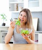 charming woman  enjoying a healthy salad sitting at the table