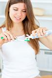 Beautiful woman using a toothbrush and toothpaste in the bathroo
