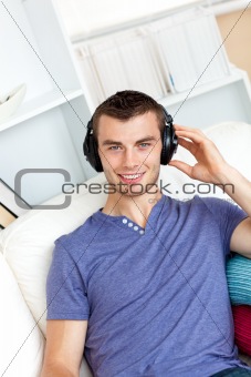Relaxed young man listening to music with headphones looking at 
