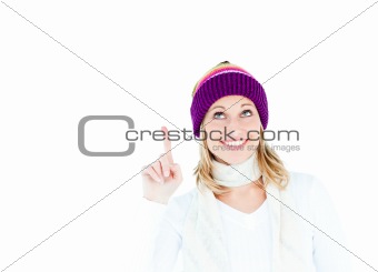 Young caucasian woman wearing a colorful hat pointing upwards wi