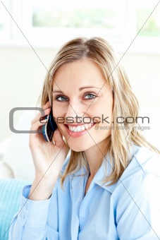 Cheerful businesswoman using her cellphone at home