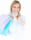 Delighted woman with thumb up holding shopping bags
