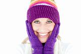 Radiant young woman with cap and gloves in the winter smiling at