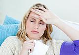 Sick woman with headache lying on the sofa in the living-room