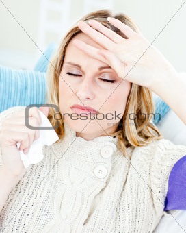 Diseased woman with headache lying on the sofa in the living-roo