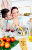 attentive man kissing his girlfriend while cooking together