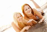 Two beautiful young girlfriends in bikini on the beach