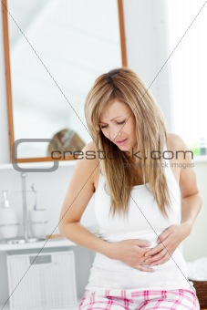 Suffering woman having a stomachache in her bathroom