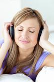 Positive caucasian woman listening to music with headphones in t