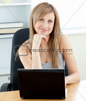 Charismatic young businesswoman using her laptop sitting at her 