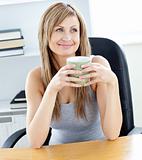Relaxed businesswoman holding a cup of coffee in her office