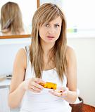 Diseased woman holding pills in the bathroom