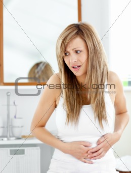 Attractive woman having a stomachache in the bathroom