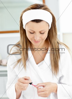 Sophisticated caucasian woman varnishing her fingernails in the 