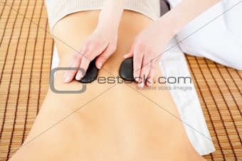 Close-up of a caucasian woman receiving a back massage with hot 