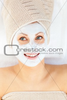 Radiant young woman having white cream on her face  