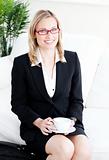 confident business woman with glasses drinking coffee at home