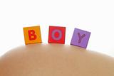 Word boy written with colorful alphabet cubes on pregnant belly