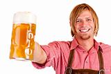 Happy smiling man with leather trousers (lederhose) holds oktoberfest beer stein