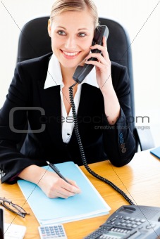 Self-assured businesswoman talking on phone and writing in her o