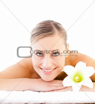 Close-up of a positive woman lying on a massage table with a flo