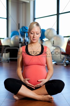 Pregnant woman holding her belly and relaxing.