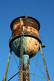 Old rusty watertower against blue sky