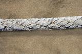 aged marine rope over beach sand background