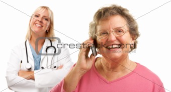Happy Senior Woman Using Cell Phone with Female Doctor or Nurse Behind Isolated on a White Background..