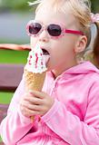 Little blond girl eating ice-cream