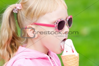 Little blond girl eating ice-cream