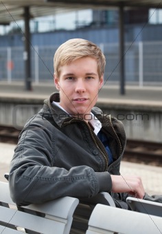 Young blond man in railway station