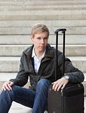 Young blond man with suitcase