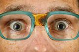 Eyes of surprised person in old spectacles