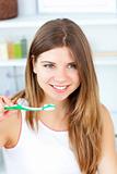 Blissful caucasian woman holding a toothbrush in the bathroom