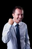 Portrait of a very happy  businessman with his arm raised, on black background. Studio shot